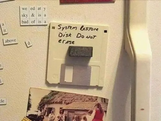 Picture of a floppy disk attached to a fridge door with a magnet labeled: "System restore disk do not erase"